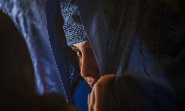 A woman speaks with an election official as she prepares to vote in the Afghan election in Mazar e Sharif in northern Afghanistan August 20, 2009. REUTERS/Caren Firouz (AFGHANISTAN POLITICS ELECTIONS)