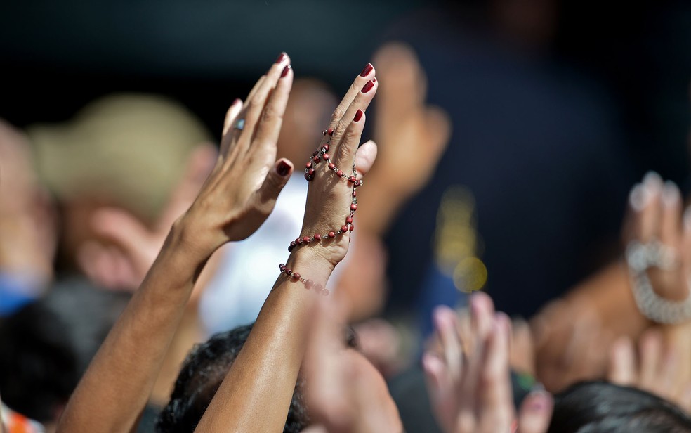 Fiel segura terço nas mãos enquanto enquanto faz oração, em foto ilustrativa — Foto: Gabriel Bouys/AFP