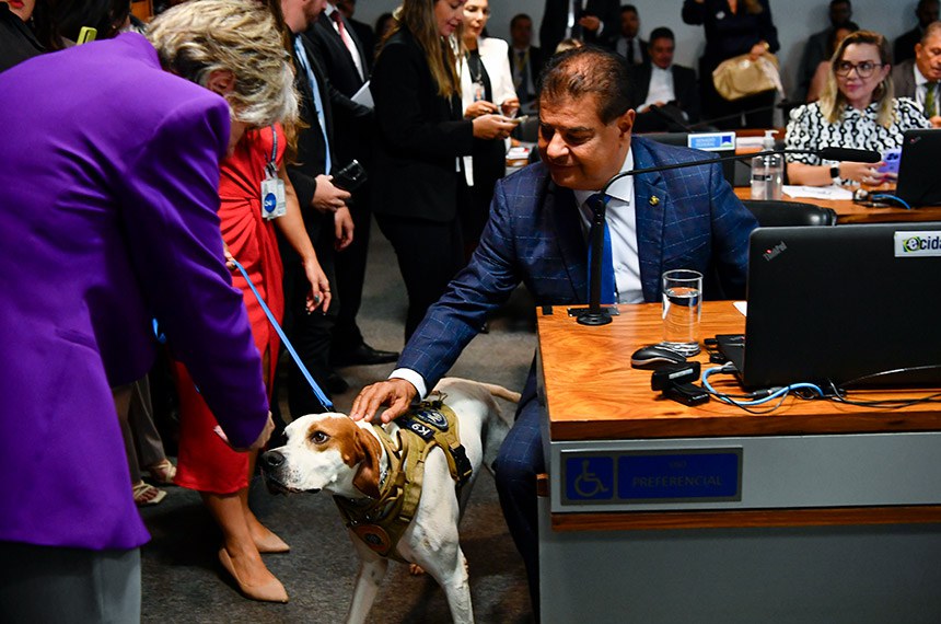 Cão farejador K9 Hummer recebendo carinho da senadora Margareth Buzetti (PSD-MT) e do senador Nelsinho Trad (PSD-MS).