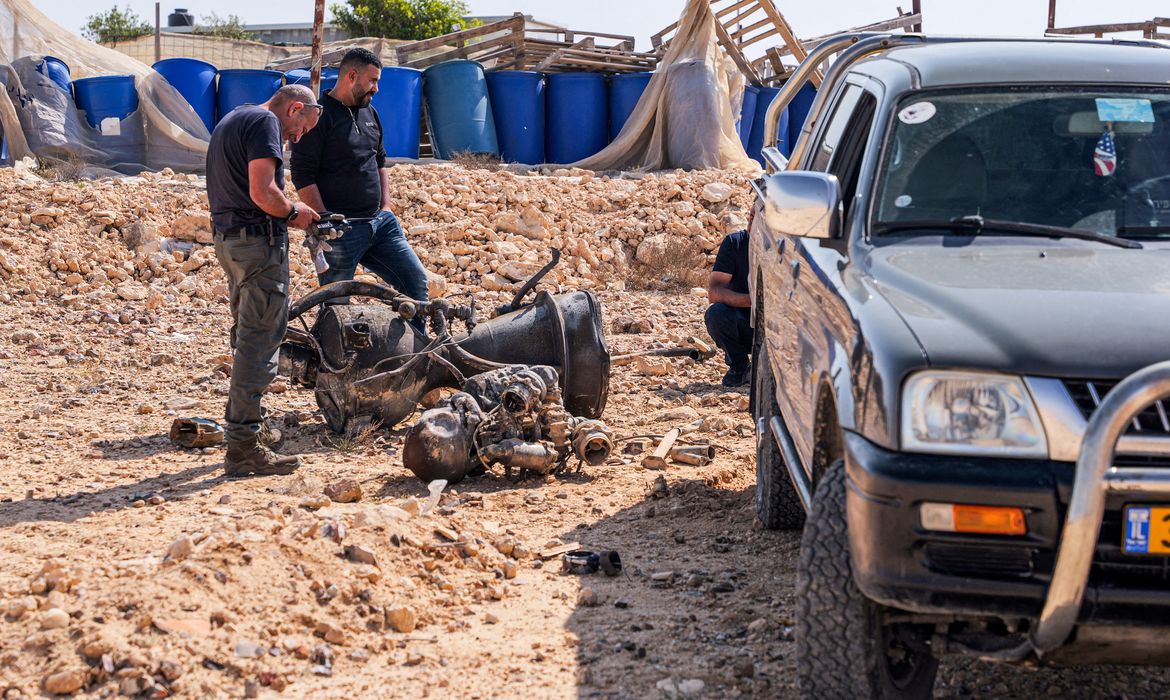 A police officer inspects the remains of a rocket booster that, according to Israeli authorities critically injured a 7-year-old girl, after Iran launched drones and missiles towards Israel, near Arad, Israel, April 14, 2024.
