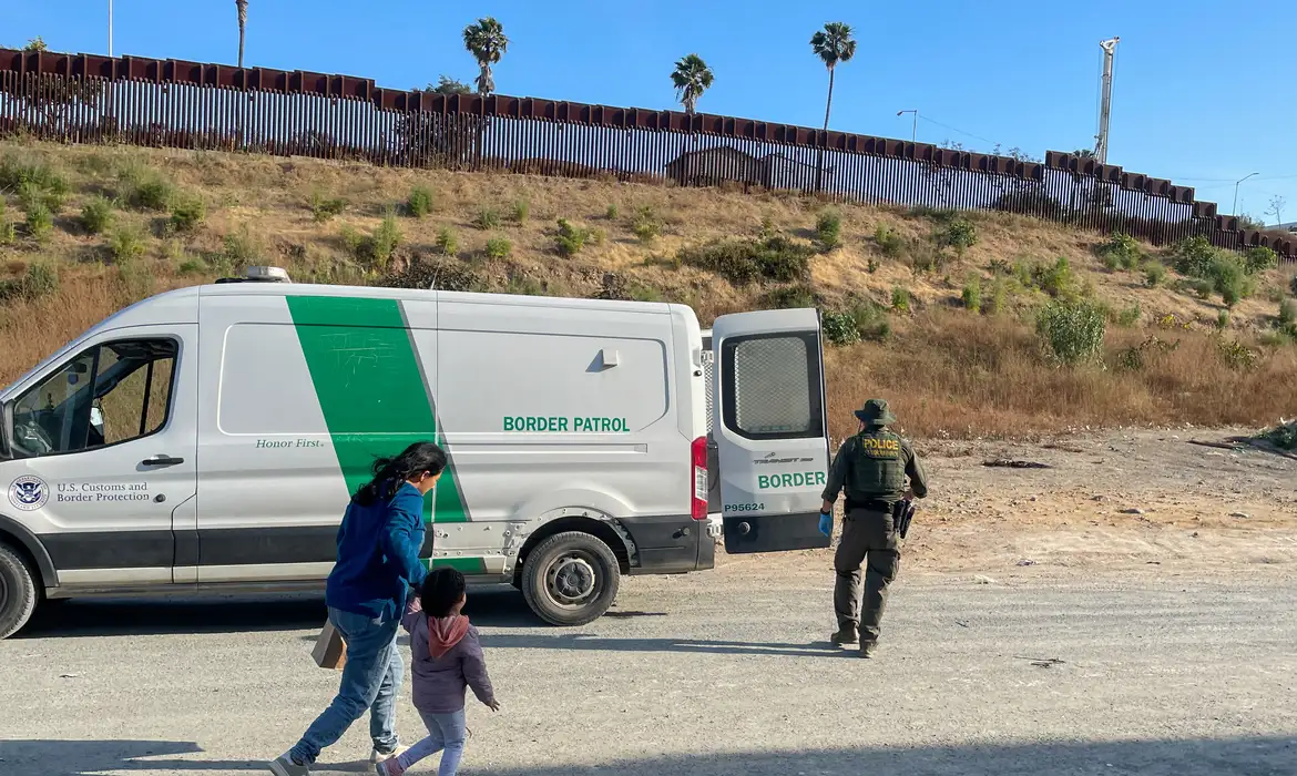Um agente da Patrulha de Fronteira dos Estados Unidos conduz Jessica León e sua filha para uma van em San Diego, Califórnia, EUA
4/6/2024 REUTERS/Daniel Trotta